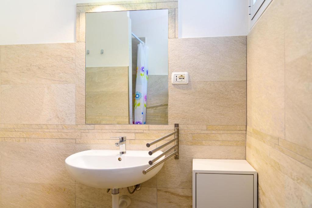 łazienka z umywalką i lustrem w obiekcie Villa I Coralli w mieście Portoferraio
