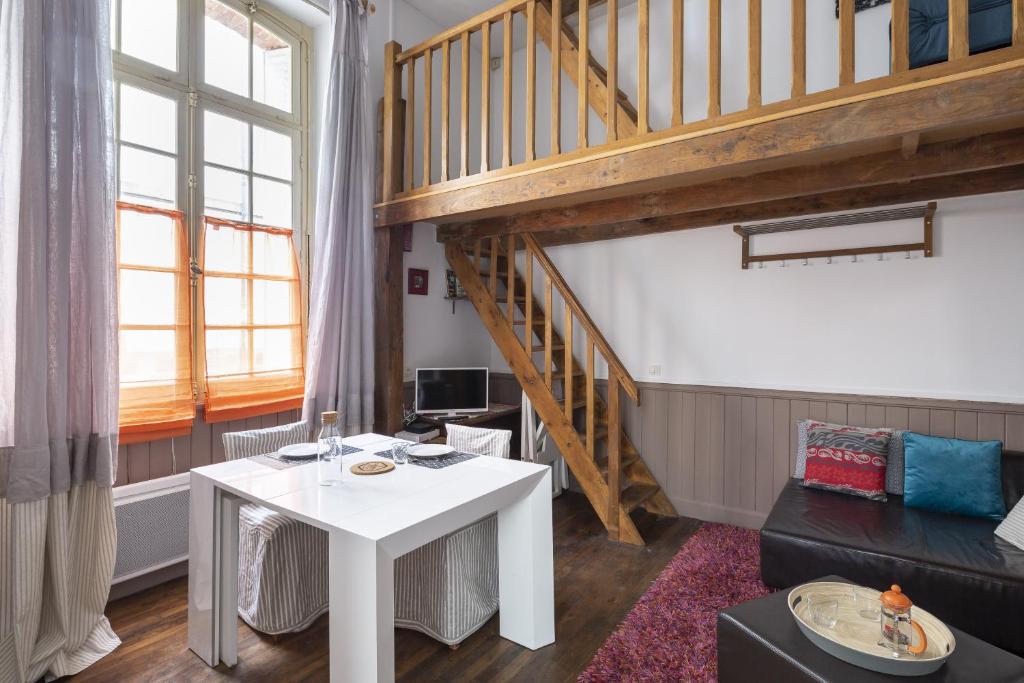 - un salon avec une table blanche et un escalier dans l'établissement Le Petit Mont by Cocoonr, à Rennes