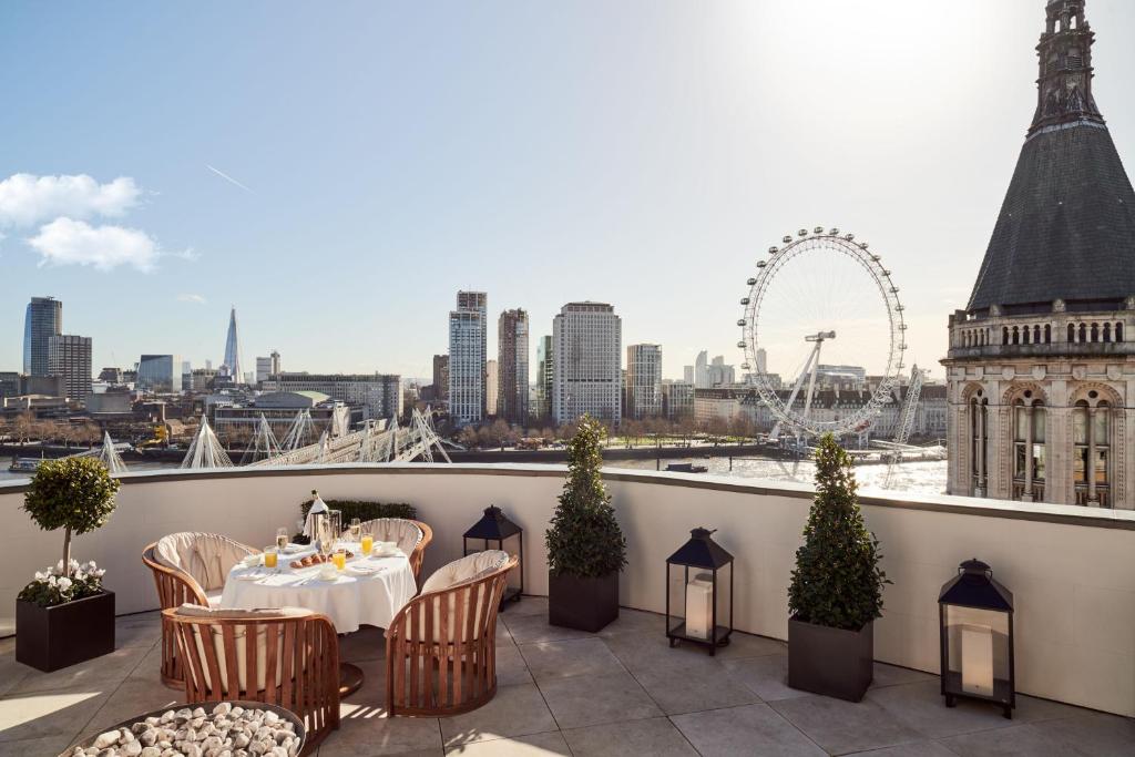 einen Tisch auf einem Balkon mit Stadtblick in der Unterkunft Corinthia London in London