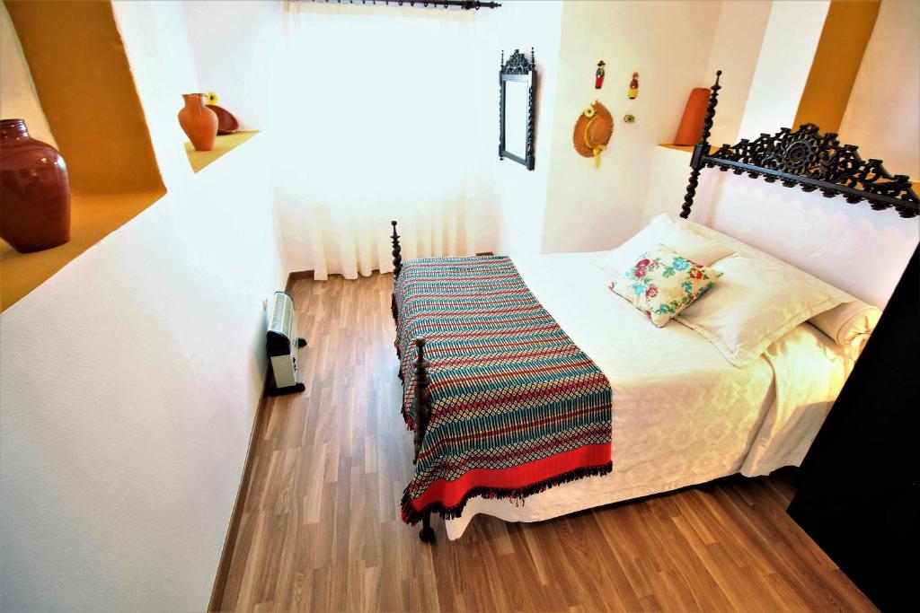 Un dormitorio con una cama con una manta. en Casa do Castelo, en Elvas