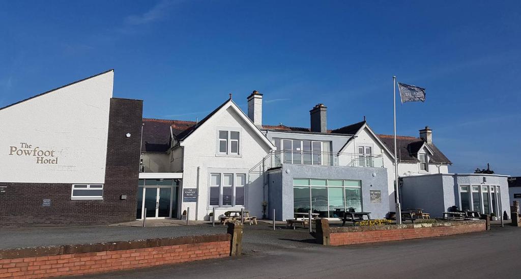 um grande edifício branco com uma bandeira em frente em The Powfoot Hotel, Annan em Annan