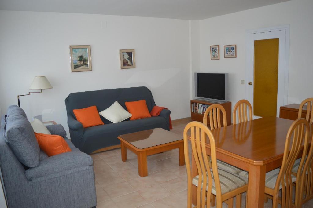 a living room with a couch and a dining room table at Apartamento Completo 200m Playa in Roses