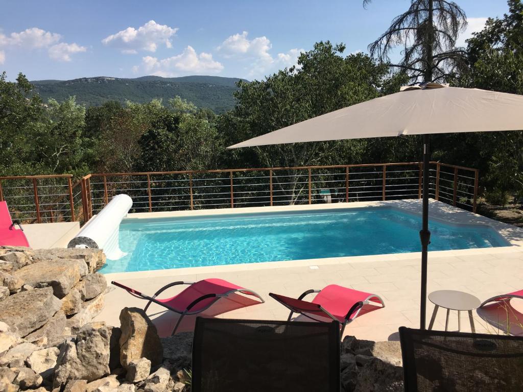 - une piscine avec des chaises et un parasol dans l'établissement DOMAINE VILONAPA - villa Figuier et villa Murier, à Saint Alban Auriolles