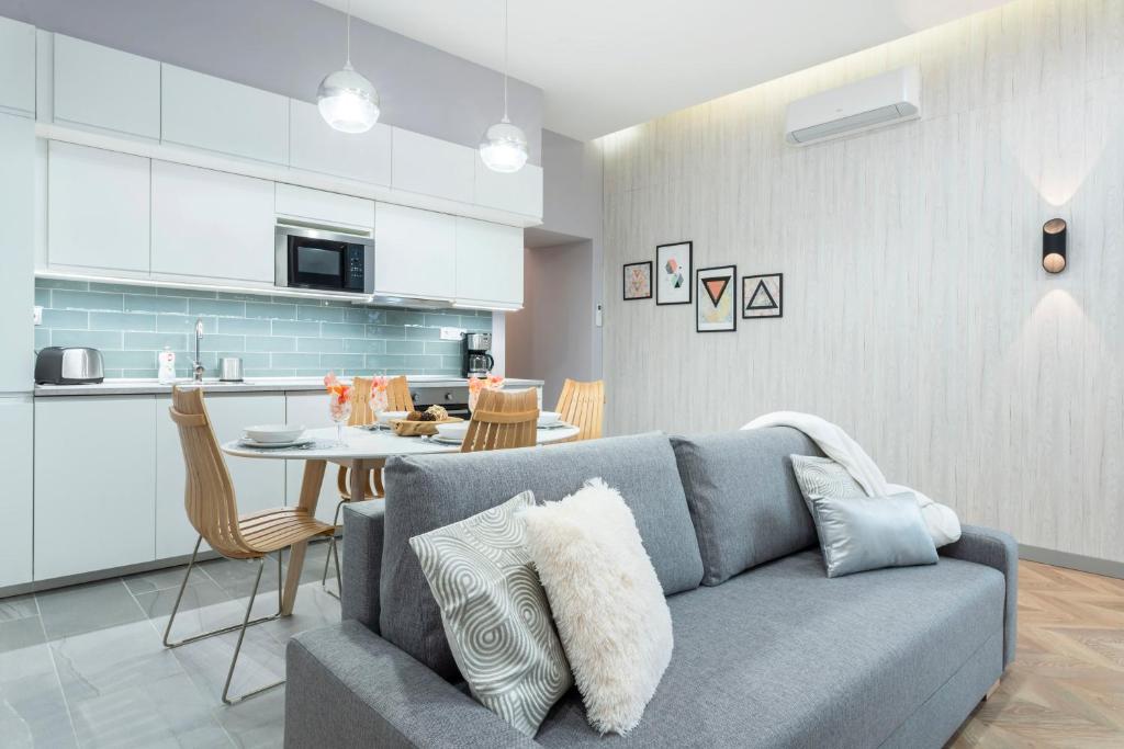ein Wohnzimmer und eine Küche mit einem Sofa und einem Tisch in der Unterkunft Modern 2 bedroom apartment with free airport transfer in Budapest