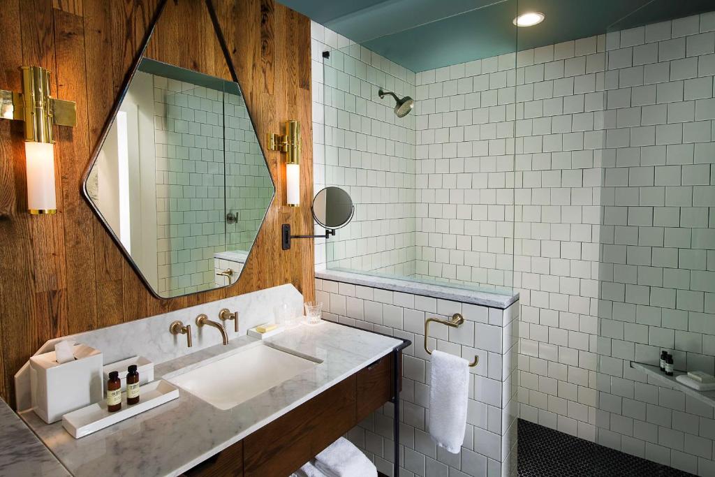 a bathroom with a sink and a mirror at Thompson Nashville, by Hyatt in Nashville