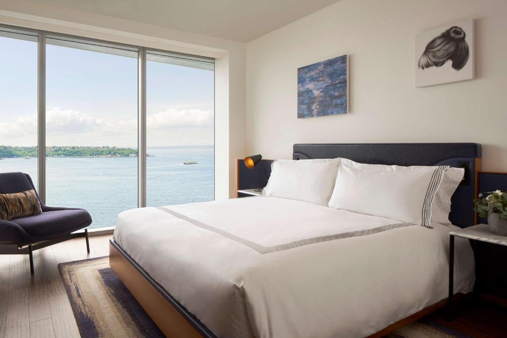 a bedroom with a large bed and a large window at Thompson Seattle, by Hyatt in Seattle