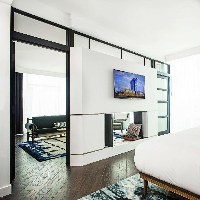 a bedroom with a bed and a tv on a wall at Thompson Nashville, by Hyatt in Nashville