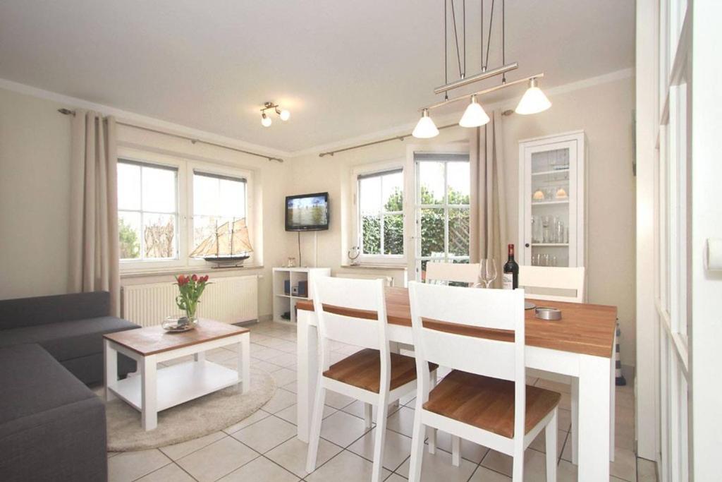 eine Küche und ein Wohnzimmer mit einem Tisch und Stühlen in der Unterkunft Haus Jenny Wohnung E1 mit Terrasse in Boltenhagen