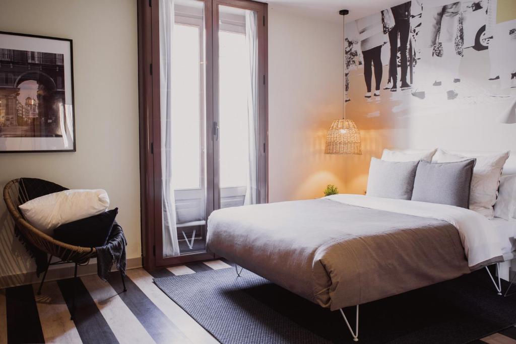 a bedroom with a large bed and a chair at room Select Sol in Madrid