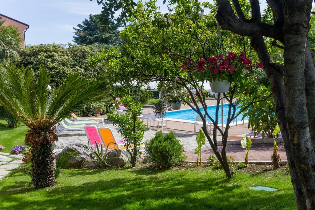 un giardino con piscina e un cortile con piante di Le Villette di Villa Paola a Loano