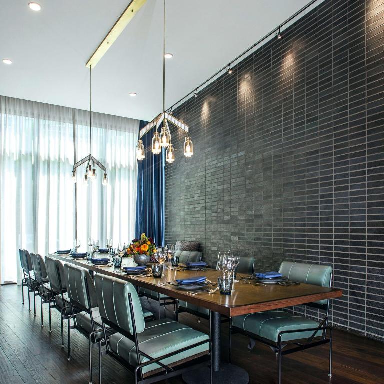 a dining room with a long table and chairs at Thompson Nashville, by Hyatt in Nashville