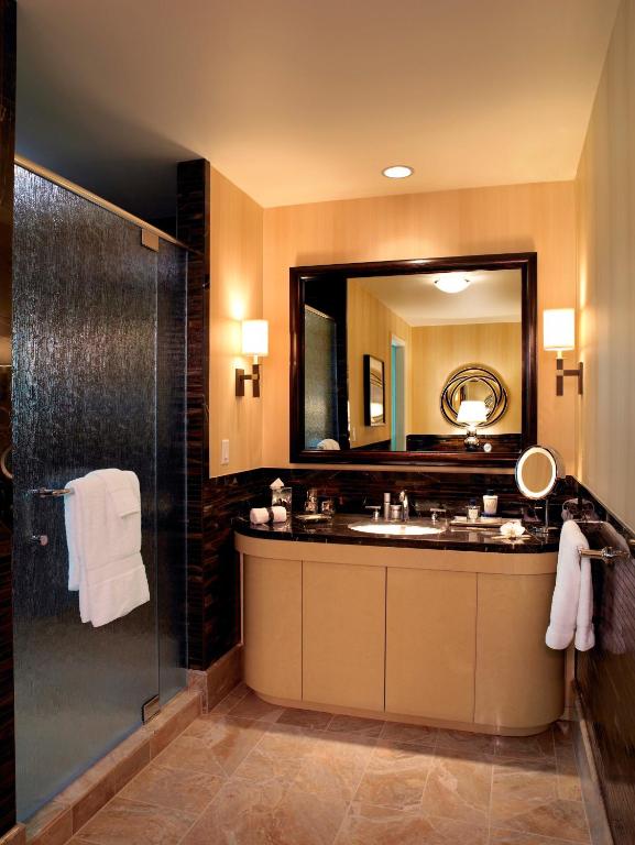 ein Badezimmer mit Waschbecken und Dusche mit Spiegel in der Unterkunft Trump International Hotel Las Vegas in Las Vegas
