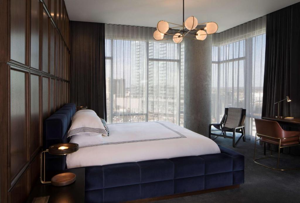 a bedroom with a large bed and a large window at Thompson Nashville, by Hyatt in Nashville