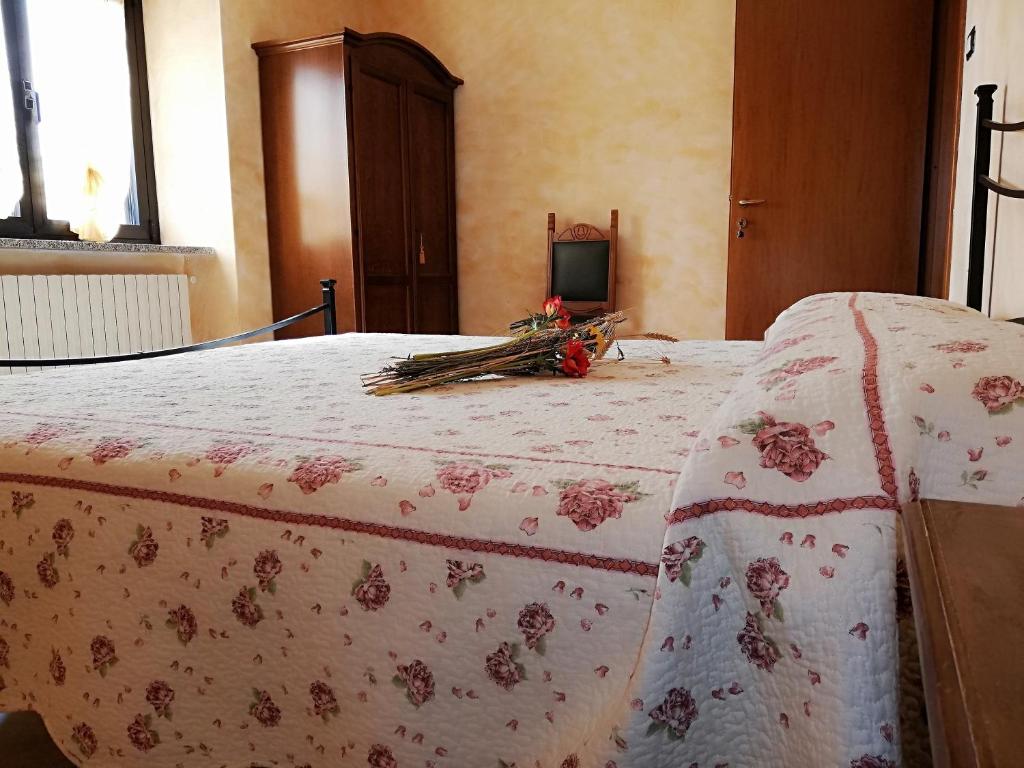 a bedroom with a bed with a flowered blanket on it at B&B Pivi in Ponti Sul Mincio