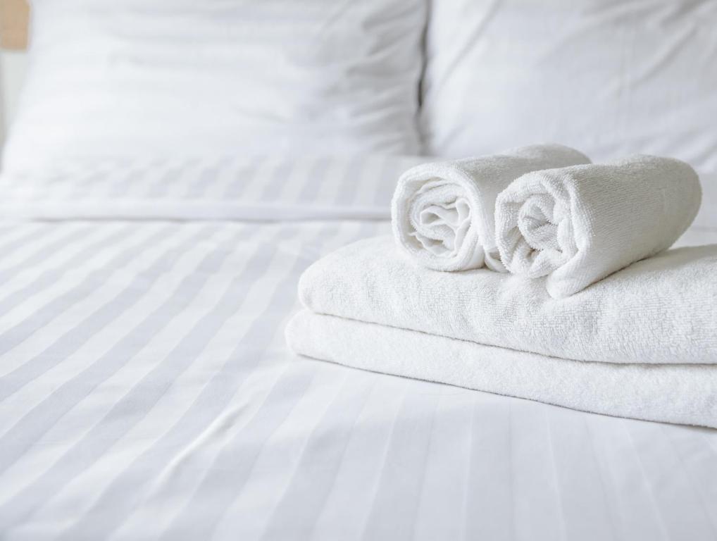 a stack of towels sitting on a bed at Super 8 by Wyndham Spruce Grove in Spruce Grove