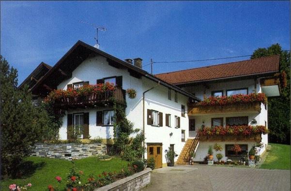 a large white house with flowers in the yard at Gästehaus Zoller - Rettenberg im Allgäu in Rettenberg
