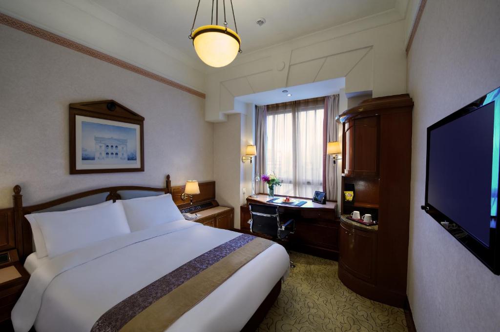 a hotel room with a bed and a flat screen tv at Charterhouse Causeway Bay in Hong Kong