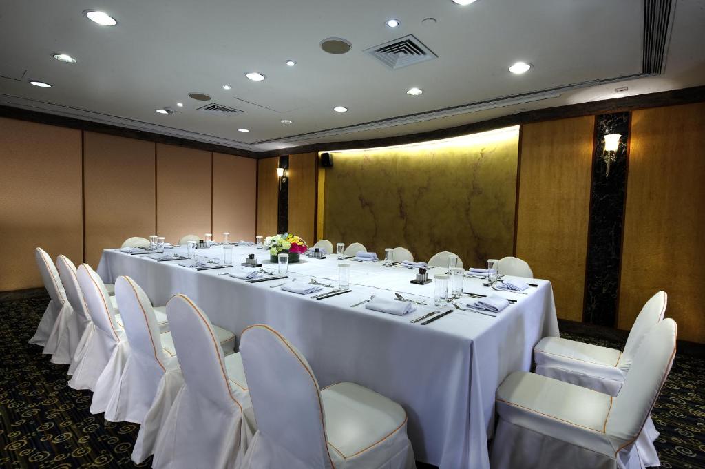 una sala conferenze con un lungo tavolo e sedie bianche di Charterhouse Causeway Bay a Hong Kong