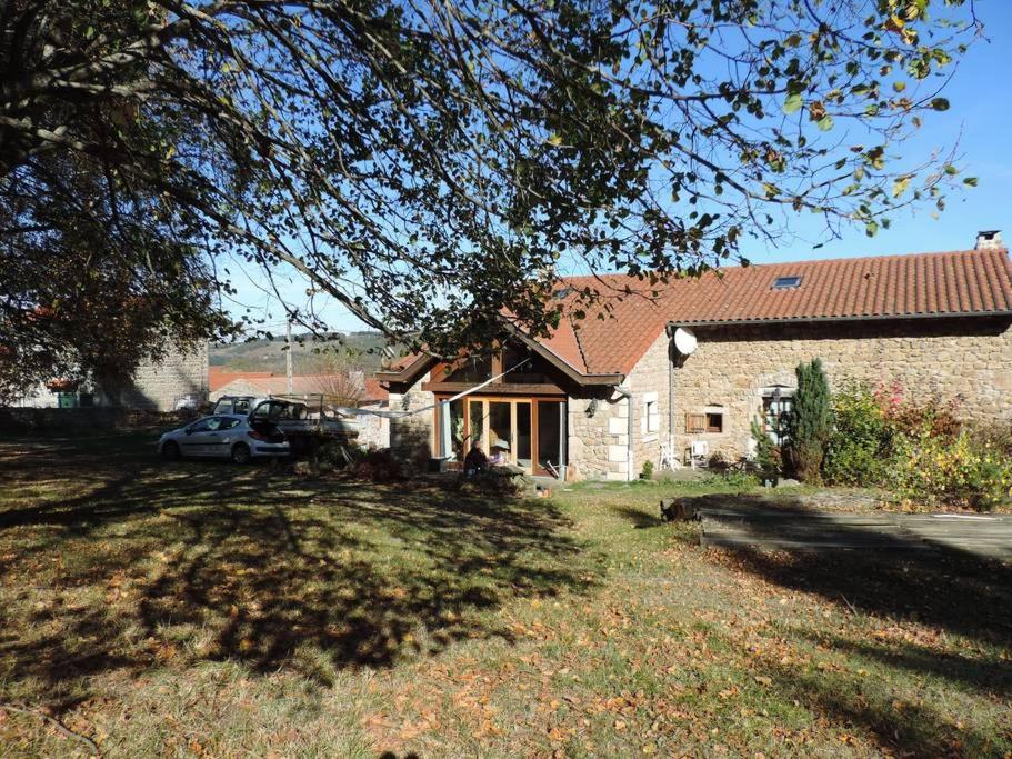 una casa con un coche aparcado delante de ella en chambre à la campagne Saint André de Chalencon, en Saint-André-de-Chalençon