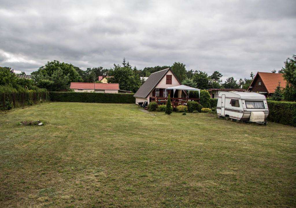 a yard with a tent and a van parked in it at Domek Jantar in Jantar