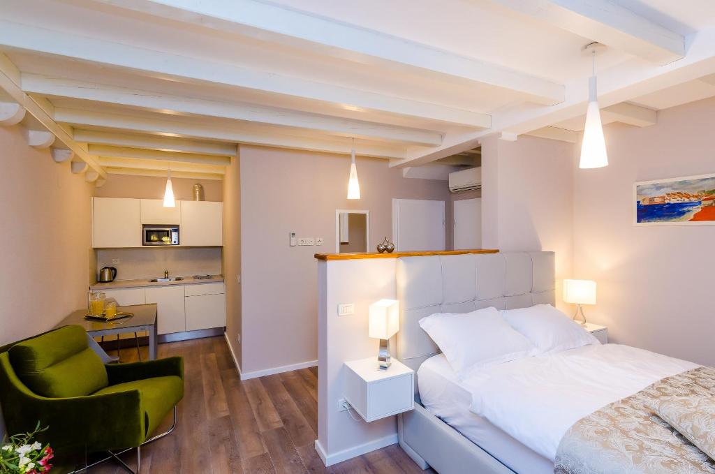 1 dormitorio con 1 cama blanca y 1 silla verde en Villa Flores Studio Apartment en Dubrovnik