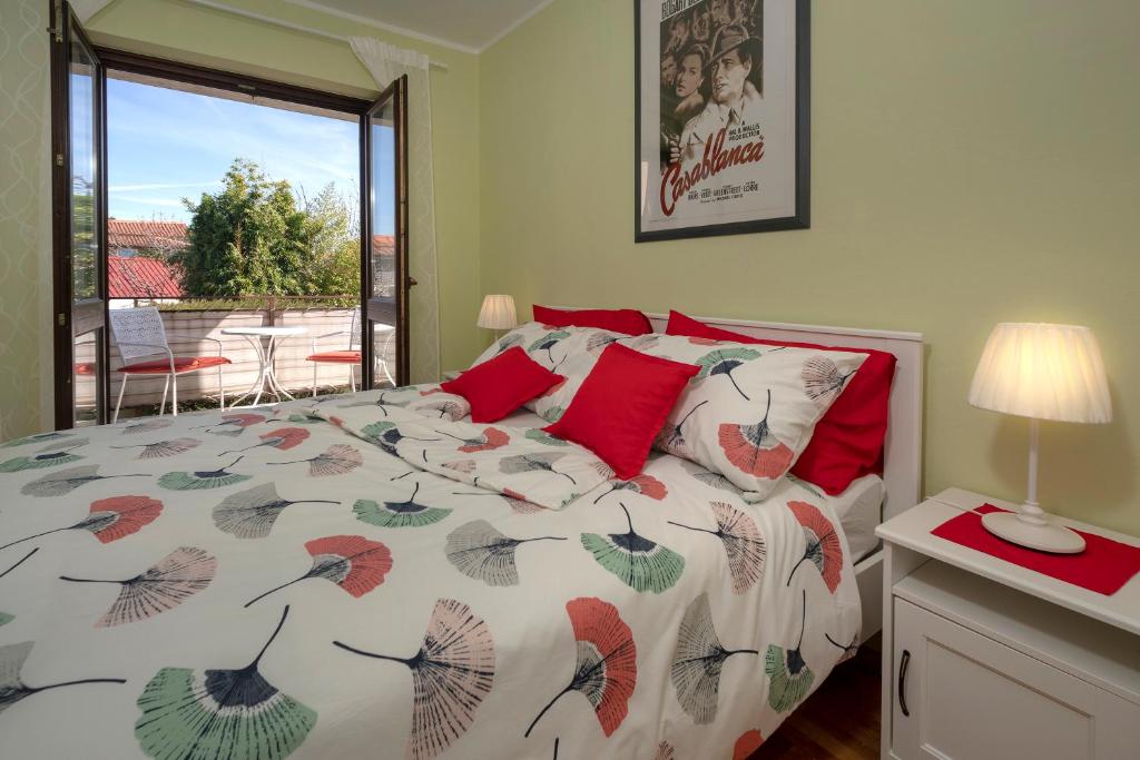 Un dormitorio con una cama con almohadas rojas y una ventana en Apartment KIKA, en Poreč