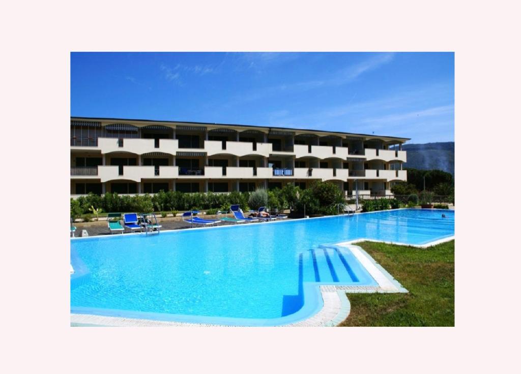 un hotel con una grande piscina di fronte a un edificio di Residenza VerdeBlu by SolturElba a Capoliveri