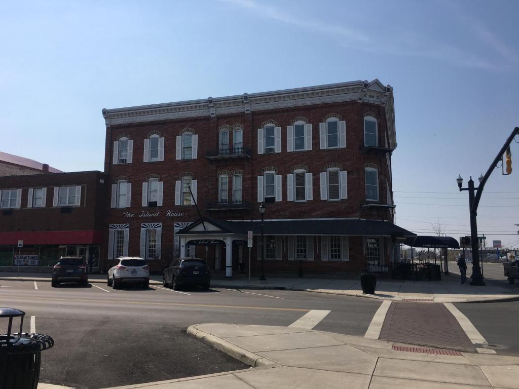 a large red brick building on a city street at Island House Historic Vacation Rentals in Port Clinton