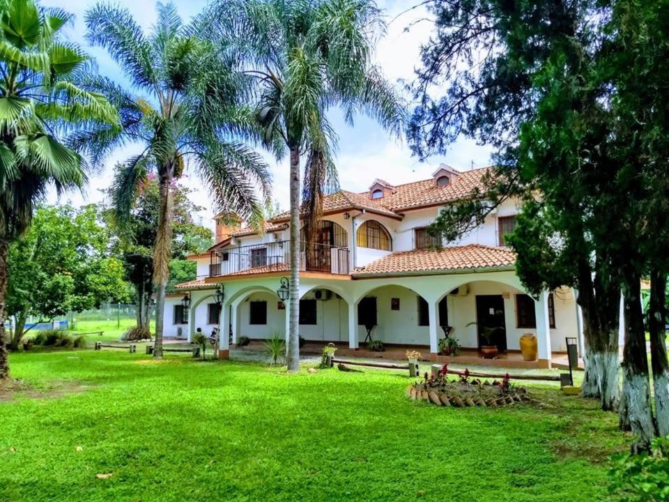 ein großes Haus mit Palmen im Hof in der Unterkunft El Portal de Cerrillos, Hostería de Campo in Cerrillos