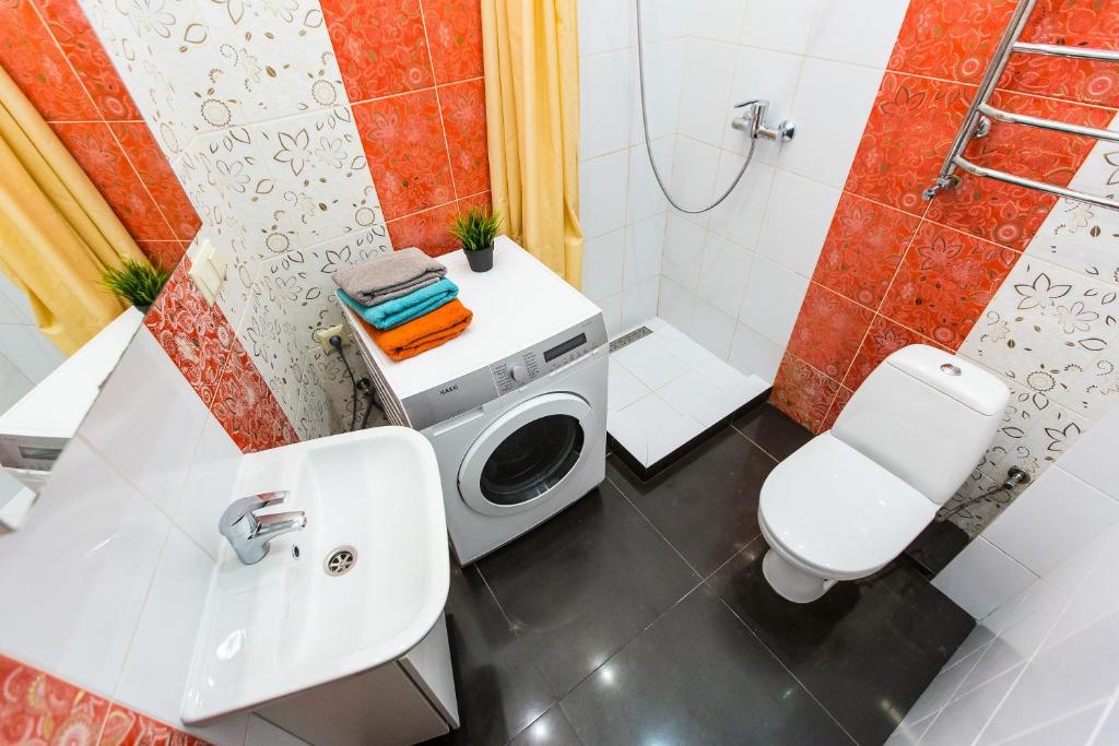 a bathroom with a toilet sink and a washing machine at Baker's street in Lviv