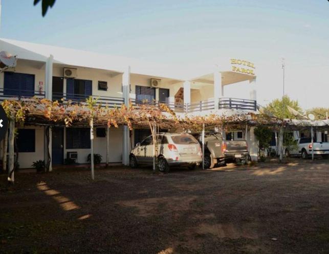 a building with two cars parked in a parking lot at Hotel Farol in Pôrto Xavier