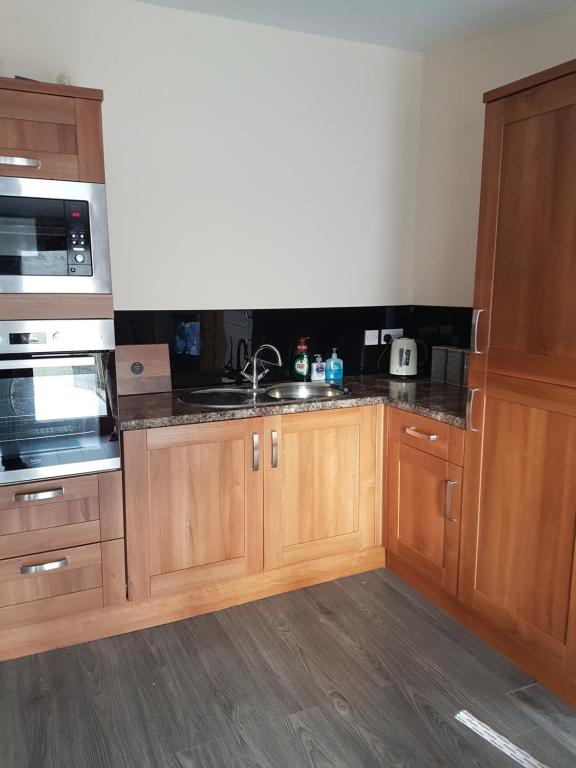 a kitchen with wooden cabinets and a sink at Flat by the Sea in Burghead