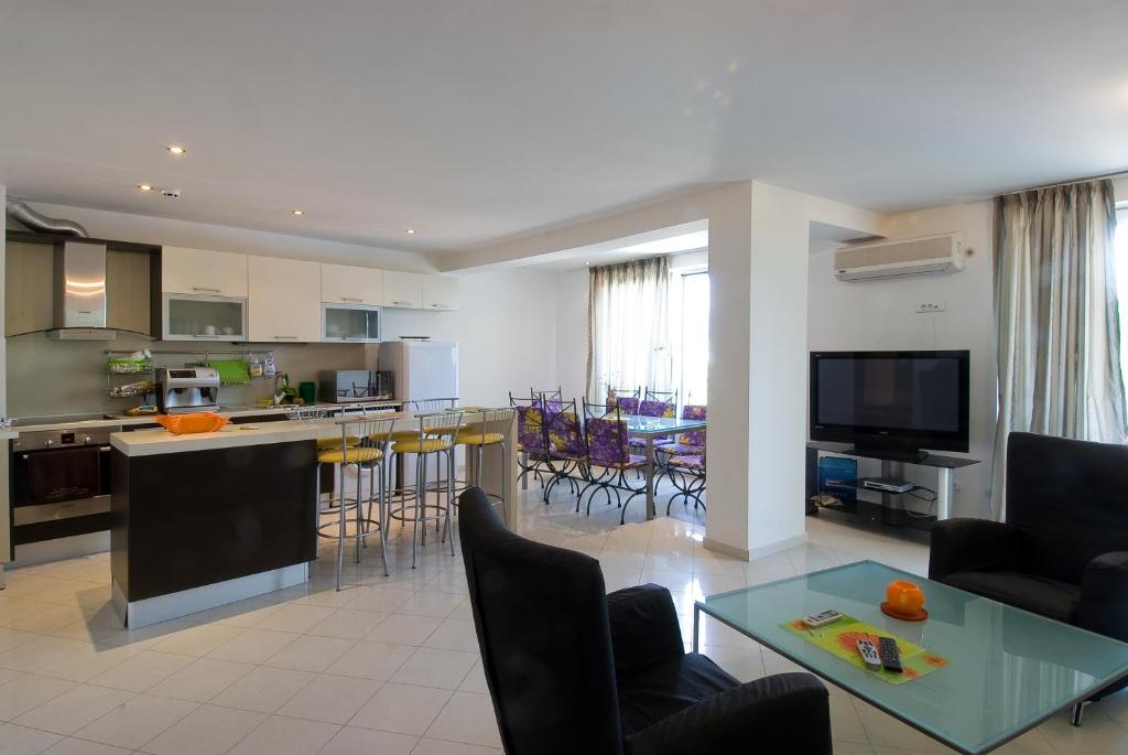 a living room and kitchen with a table and chairs at MNG Holiday Yassen Apartments in Sunny Beach