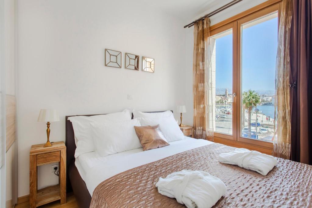 a bedroom with a large bed with a large window at New luxury apartment Nives on seaside in Split