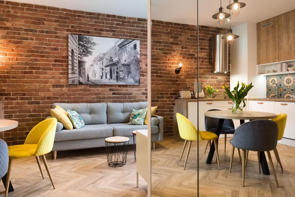 a living room with a couch and a table and chairs at apartamenty Stary Kraków GO in Kraków