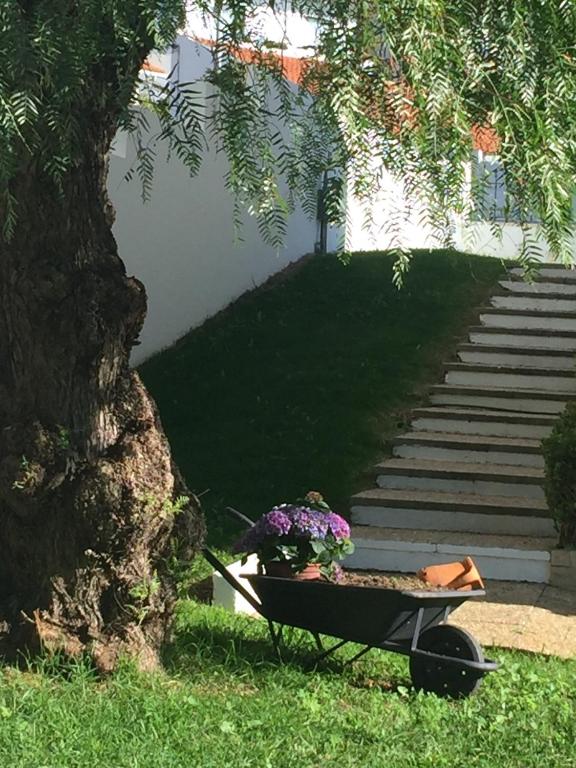 a bench with flowers on it next to a tree at Paradise Suites in Carcavelos