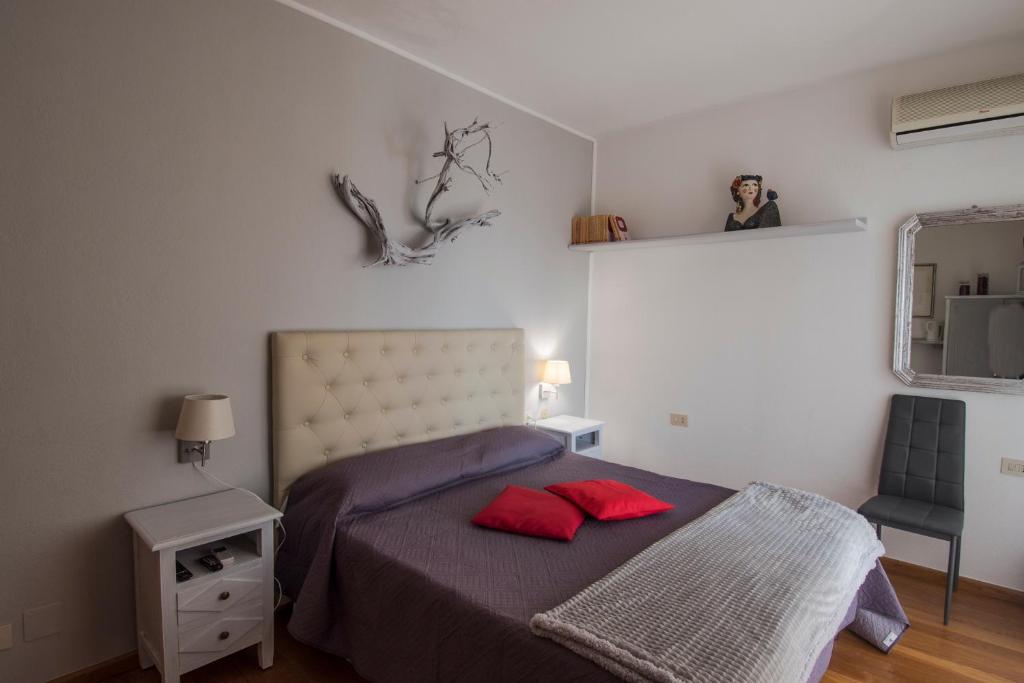 - une chambre avec un lit doté de 2 oreillers rouges dans l'établissement La Chicca di Francesca, à Santa Teresa Gallura