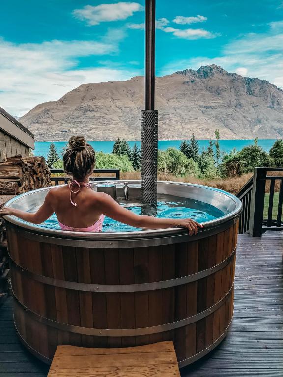 eine Frau in einem Whirlpool mit Bergblick in der Unterkunft Hidden Lodge Queenstown in Queenstown