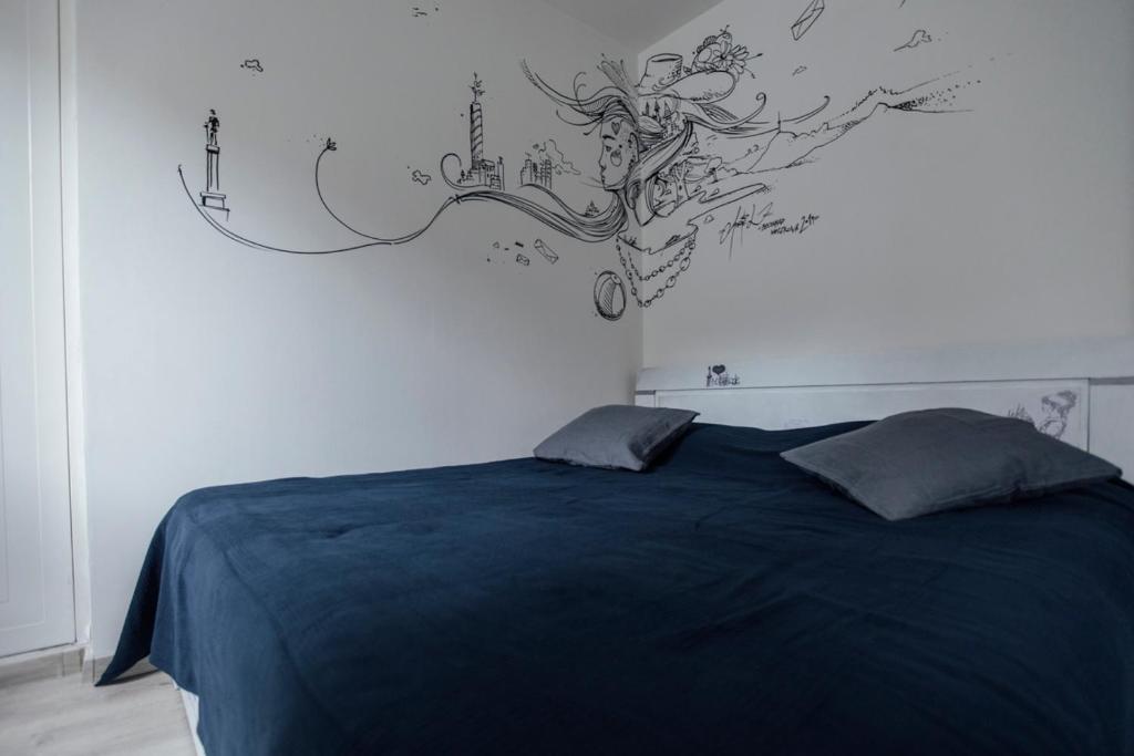 1 dormitorio con 1 cama con un mural en la pared en Molders Apartments, en Belgrado