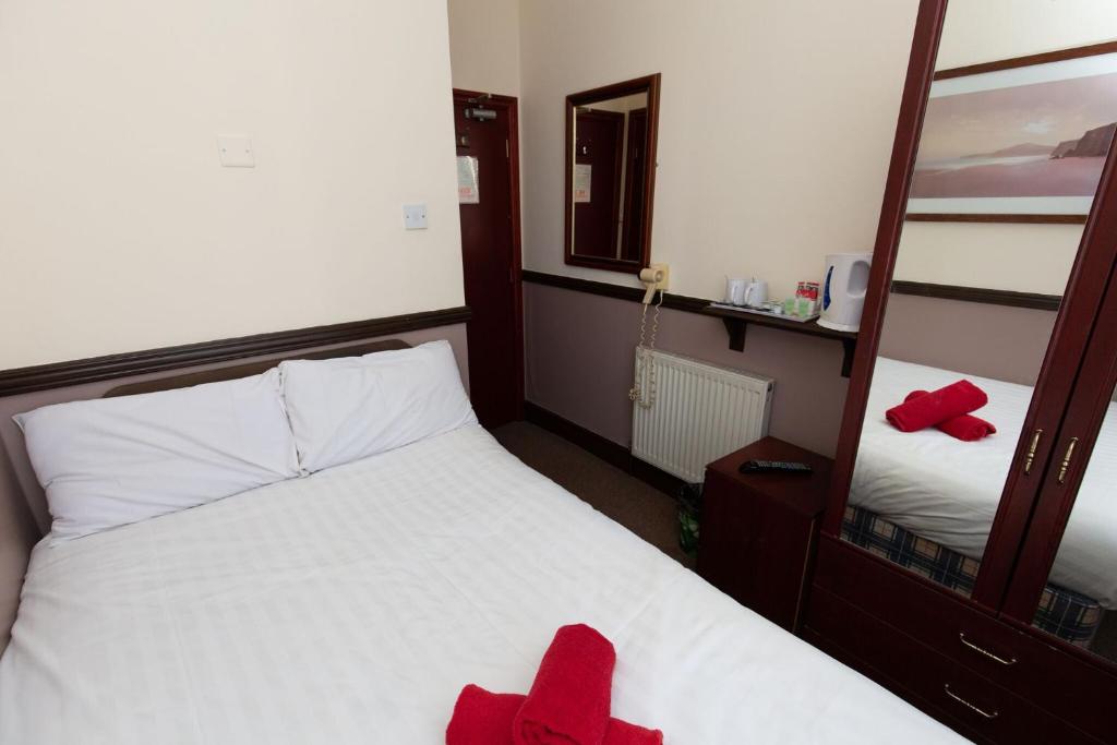 a bedroom with a bed with red towels on it at The Riviera Hotel in Blackpool