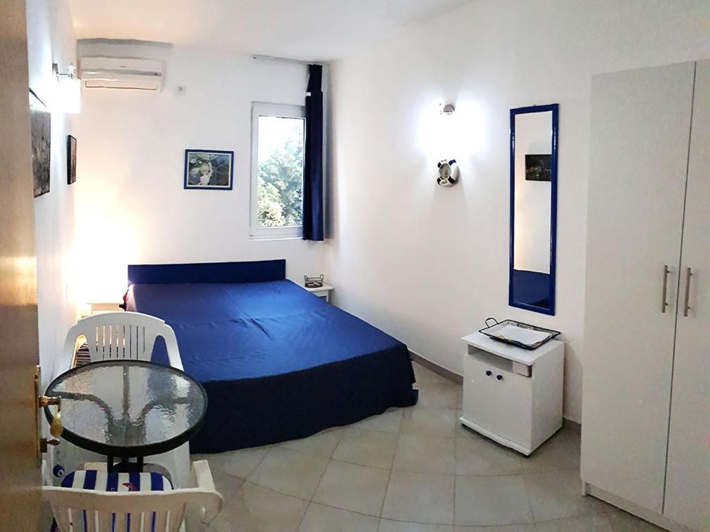 een slaapkamer met een blauw bed en een tafel bij Ratac Eco Guest House in Sutomore