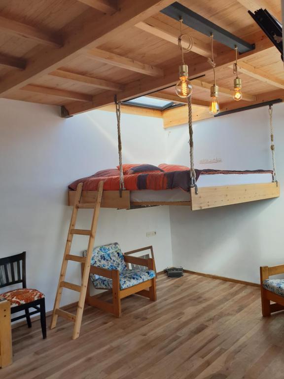 Cette chambre dispose de lits superposés, d'une échelle et d'une chaise. dans l'établissement The Rooftop, à Essaouira
