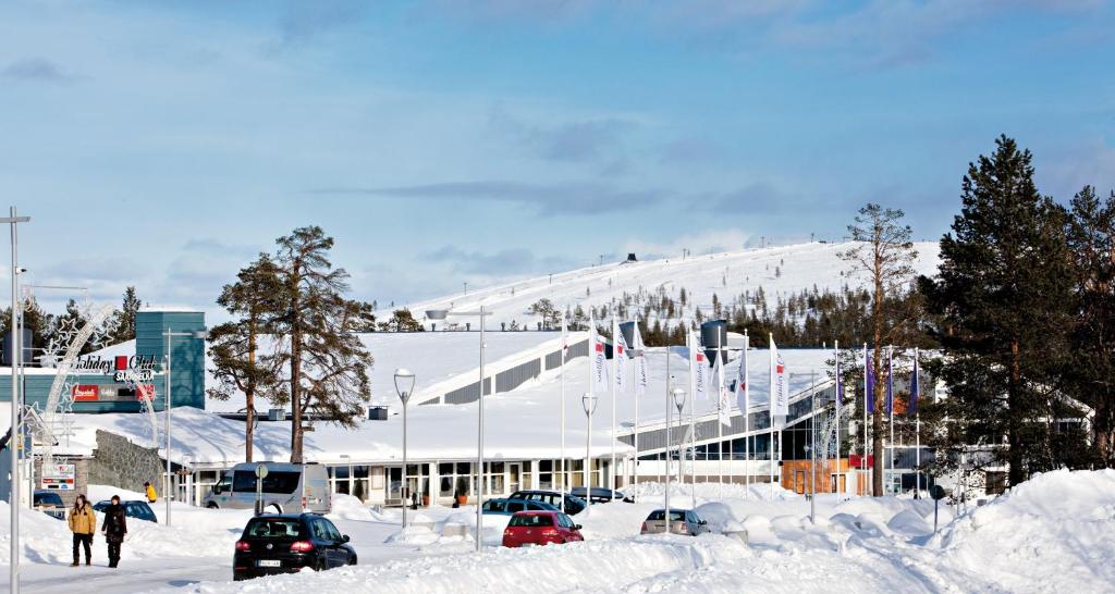 a snow covered slope with a building on top of it at Holiday Club Saariselkä in Saariselka