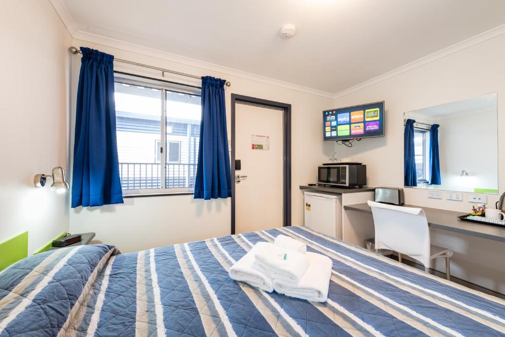 a hotel room with a bed and a kitchen at Jolly Swagman Acccommodation Park in Toowoomba