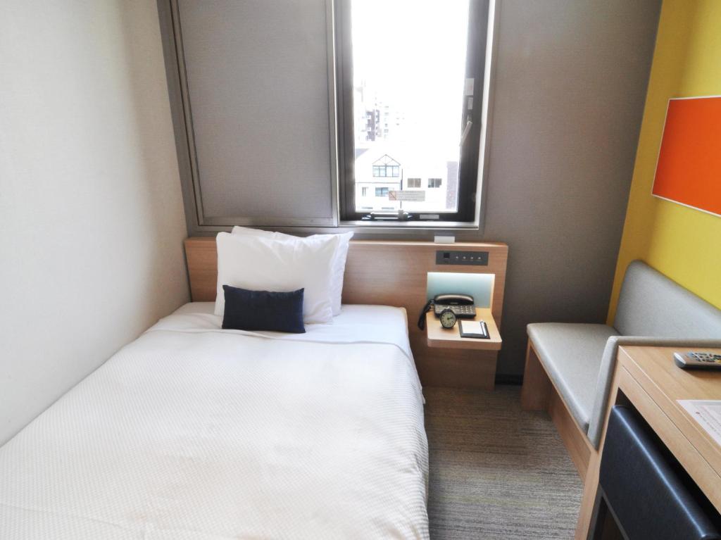 Postel nebo postele na pokoji v ubytování Sotetsu Grand Fresa Osaka-Namba