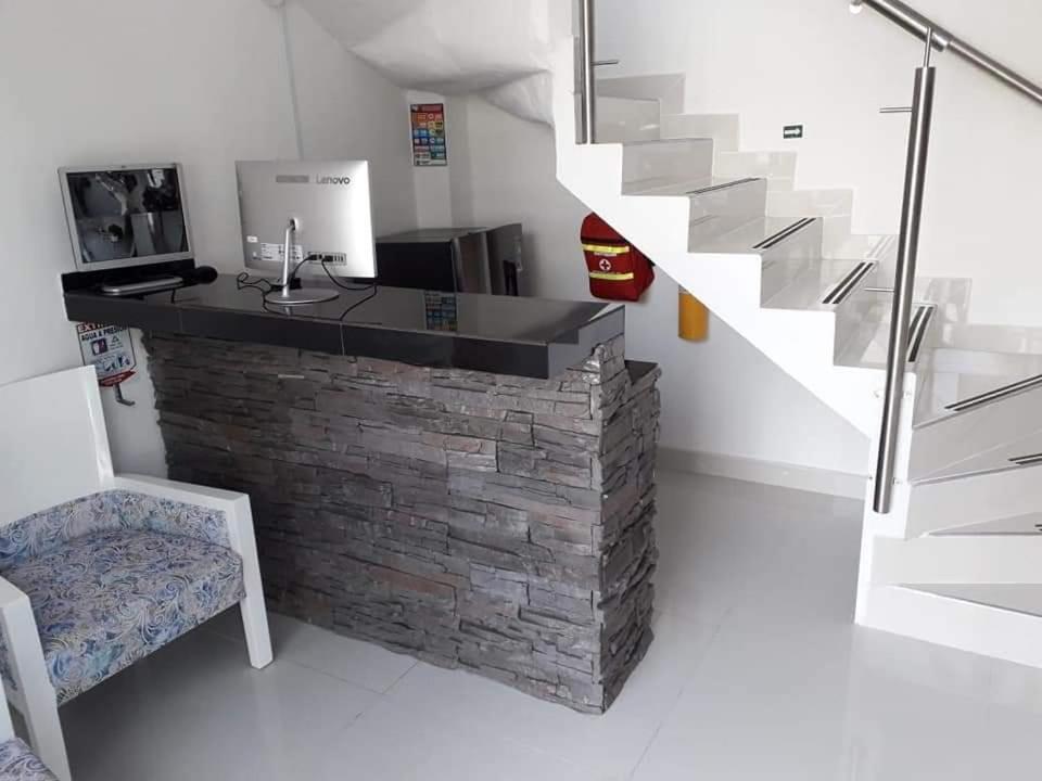 a room with a stone counter and a staircase at Hotel Limaco in Neiva