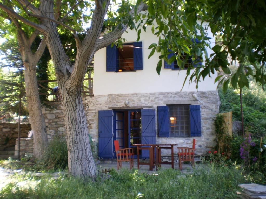 uma casa com portas azuis e uma mesa e cadeiras em DE KIRIKO em Milies