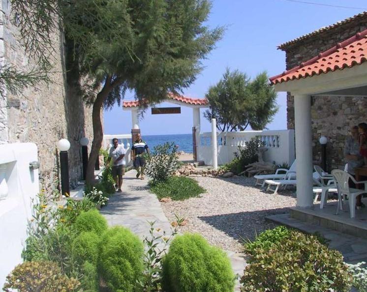 dos personas caminando por un camino al lado de una casa en Hotel Agnanti, en Ágios Konstantínos