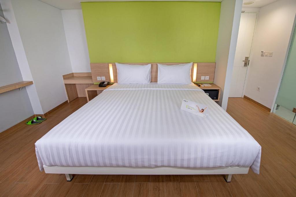 Postel nebo postele na pokoji v ubytování Whiz Prime Hotel Pajajaran Bogor