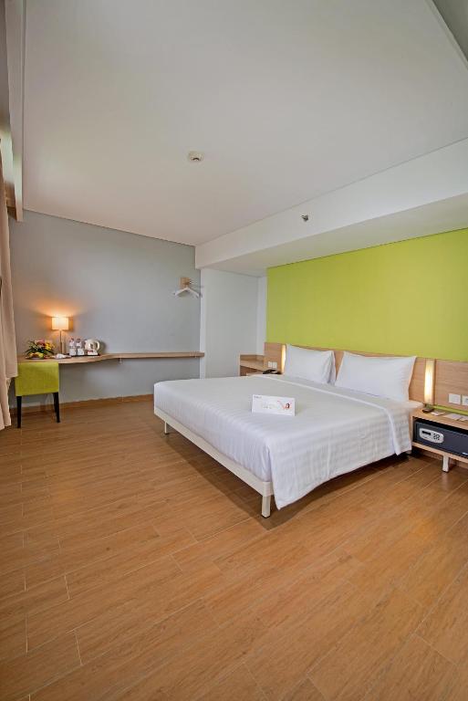Postel nebo postele na pokoji v ubytování Whiz Prime Hotel Pajajaran Bogor
